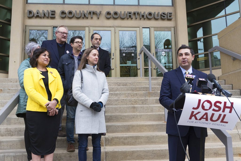 FILE - In this Wednesday, Nov. 7, 2018 file photo, Democratic candidate for state attorney general Josh Kaul, right, claims victory during a news conference at the Dane County Courthouse in Madison, Wis. Wisconsin's attorney general-elect, Kaul, campaigned on promises to pull the state out of a lawsuit challenging the Affordable Care Act and to get tougher on polluters. Republicans pushing to hang on to power in Wisconsin and Michigan are trying to hamstring Democrats who are about to take over as attorneys general. (Mark Hoffman/Milwaukee Journal-Sentinel via AP, File)