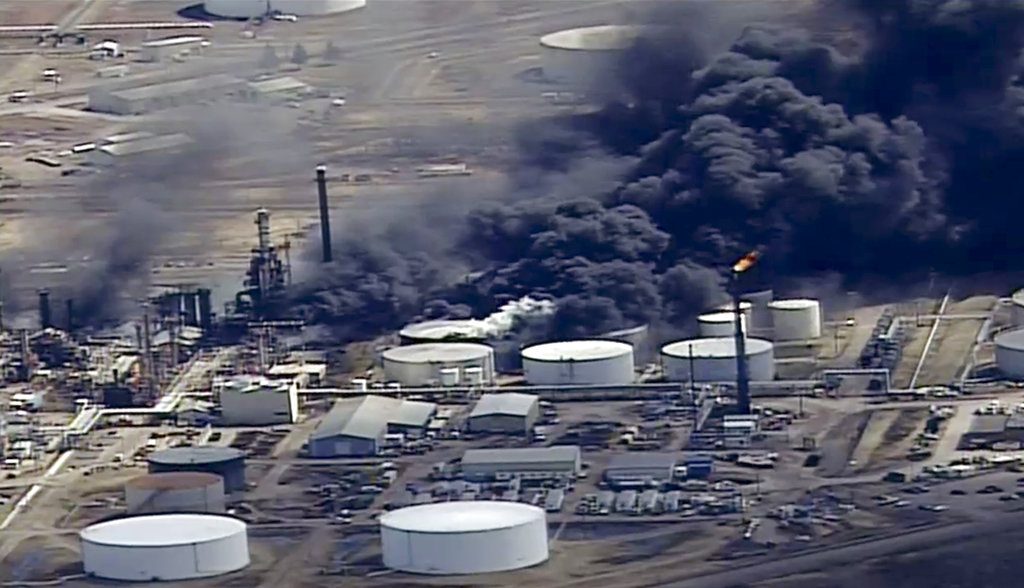 FILE - In this April 26, 2018, file image from video, smoke rises from the Husky Energy oil refinery after an explosion and fire at the plant in Superior, Wis. A hole in a valve was cited as the source of the explosion at the refinery last spring that injured 36 people and required the evacuation of a large part of the northwestern Wisconsin city. The latest findings of the U.S. Chemical Safety and Hazard Investigation Board were shared Wednesday, Dec. 12 at a town hall meeting in Superior. According to the update, erosion created a hole in the slide valve, allowing air to mix with hydrocarbons. (KSTP-TV via AP, File)