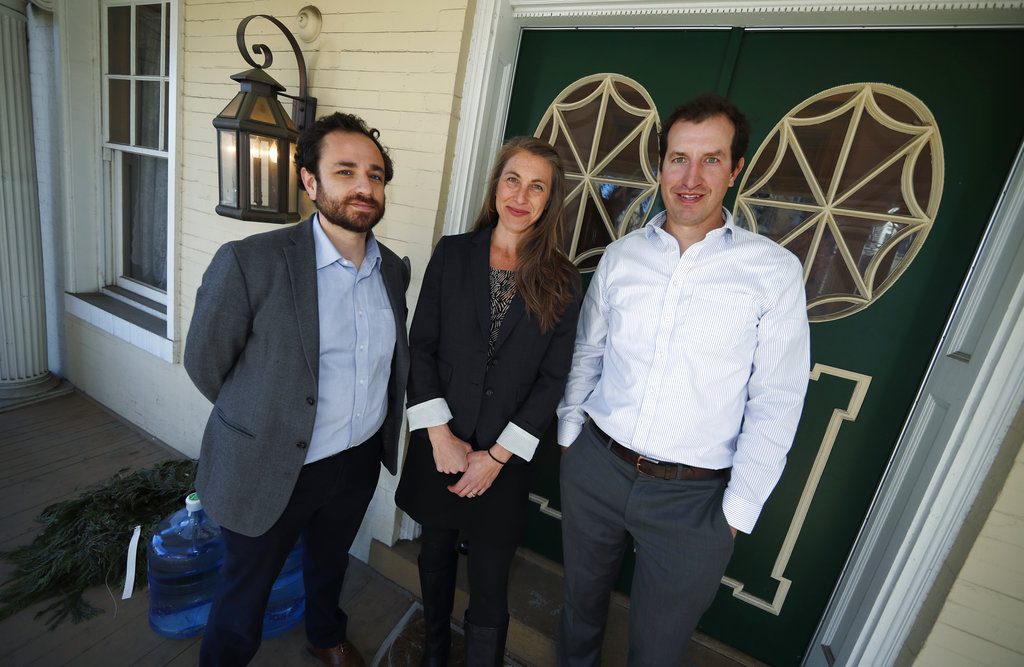 In this Thursday, Dec. 20, 2018 photo, from left, attorneys David Seligman, Nina DiSalvo and Alexander Hood of Denver's Towards Justice are shown outside the organization's office east of downtown Denver. A deal filed in federal court in Denver Wednesday, Jan. 9, 2019, will allow young people who have provided low-cost child care for American families to share in a $65.5-million class action settlement with the companies that brought the workers to the United States. (AP Photo/David Zalubowski)