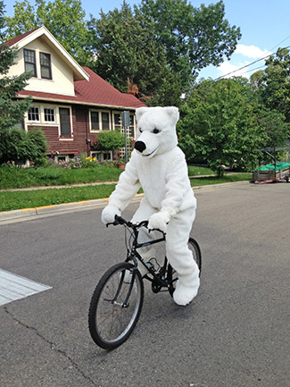 Jeff Neterval practices riding a bike for the first time in his polar bear suit in July 2014 near his home in Madison. Neterval, who runs a non-profit focused on raising awareness about protecting biodiversity and helping organizations raise money for conservation efforts, was preparing for the Boys and Girls Club of Dane County’s Bike For Boys & Girls Club event. Photo courtesy of Jeff Neterval