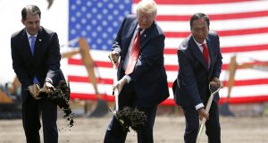 FILE - In this June 28, 2018, file photo, President Donald Trump, center, along with Wisconsin Gov. Scott Walker, left, and Foxconn Chairman Terry Gou participate in a groundbreaking event for the new Foxconn facility in Mt. Pleasant, Wis.  Foxconn Technology Group said Wednesday, Jan. 30, 2019 it is shifting the focus of its planned $10 billion Wisconsin campus away from blue-collar manufacturing to a research hub, while insisting it remains committed to creating 13,000 jobs as promised.  (AP Photo/Evan Vucci, File)