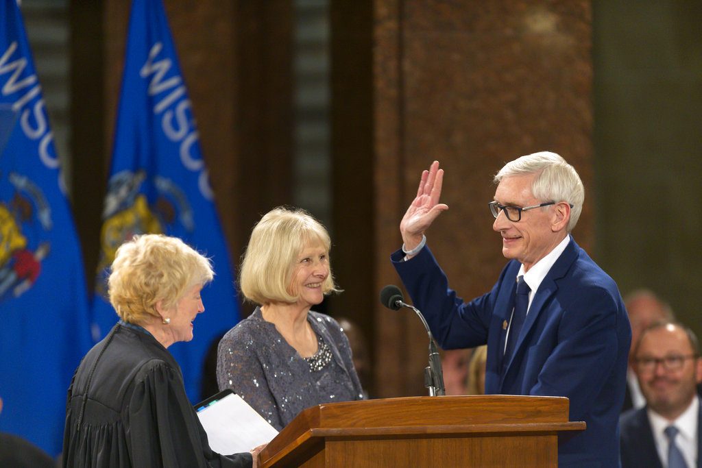 Wisconsin Gov. Tony Evers, right, is sworn in by Wisconsin Supreme Court Chief Justice Pat Roggensack as Kathy Evers watches during the inauguration ceremony at the state Capitol, Monday, Jan. 7, 2019, in Madison, Wis. (AP Photo/Andy Manis)