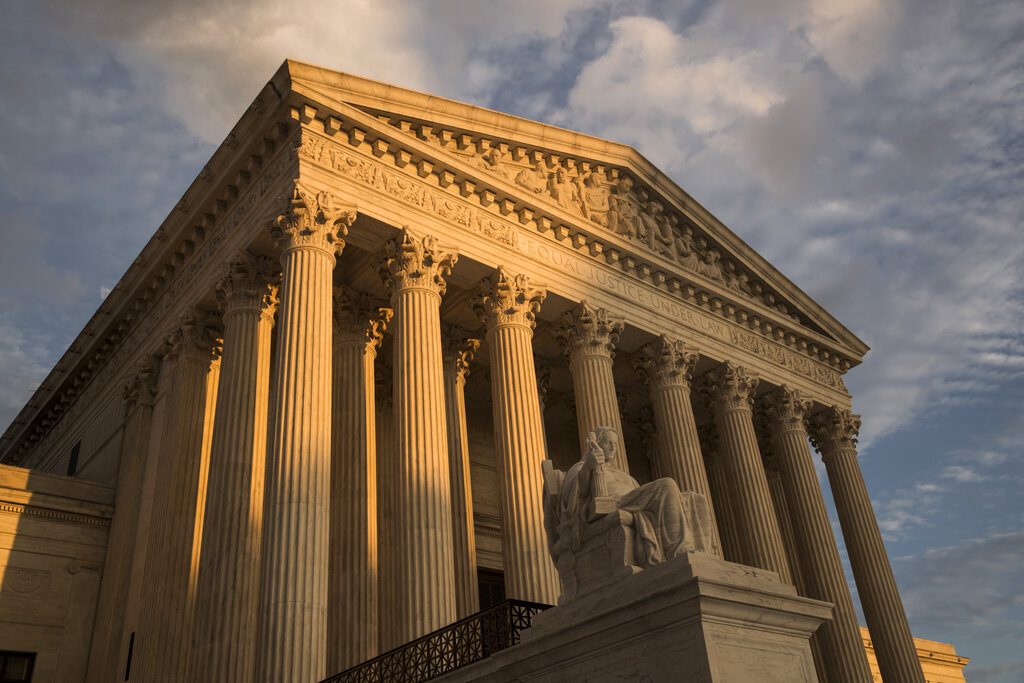 FILE - In this Oct. 10, 2017, file photo, the Supreme Court in Washington, at sunset. The Justice Department’s ability to charge minors for supporting terrorist groups has been hampered by a 2018 Supreme Court decision, forcing prosecutors to hand off at least one such case to local authorities in a state without anti-terrorism laws. (AP Photo/J. Scott Applewhite, File)