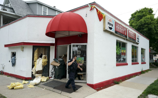 A police officer walks in front of the Lion of Judah House of Rastafari church on Wednesday in Madison. The organizers of the self-styled church were arrested for distributing marijuana in return for donations. Madison police said the raid on the storefront church was initiated by the Dane County Narcotics Task Force. (Steve Apps/Wisconsin State Journal via AP)