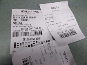 FILE - In this Oct, 12, 2018, photo, losing betting slips in Atlantic City, N.J. that had predicted the New York Yankees to either reach the World Series or win it. NBA and MLB executives staunchly believe their leagues deserve a cut of sports betting revenue. But their problem has been convincing anyone else in the sports betting world. (AP Photo/Wayne Parry, File)