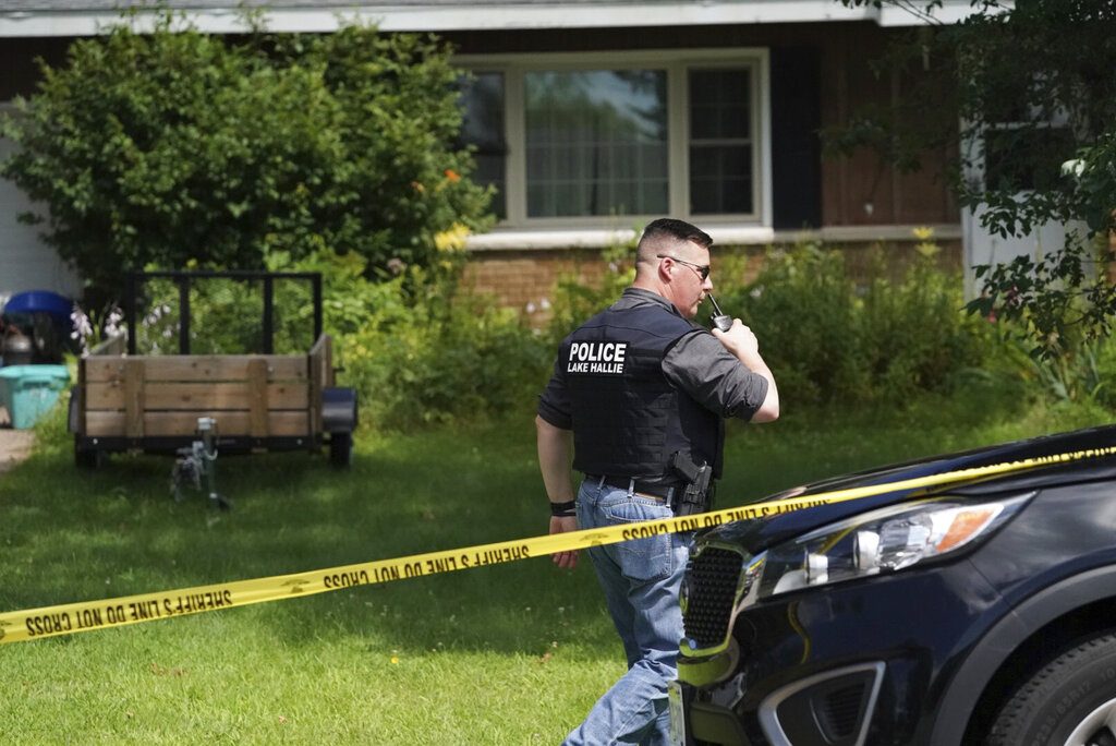 A Lake Hallie Police officer works outside a home Monday, July 29, 2019, in Lake Hallie, Wis., following a shooting the night before. Authorities in northwestern Wisconsin say shootings at two homes have left five people dead, including the suspected shooter, and two others injured. (Renee Jones Schneider/Star Tribune via AP)