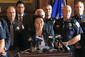 Kara Weiland talks to reporters in the state Capitol on Tuesday about a bill that would require local governments to cover health insurance premiums for slain police officers' survivors. Weiland's husband, Everest Metro Police Detective Jason Weiland, was killed during a 2017 shooting spree in the Wausau area. (AP Photo/Todd Richmond)