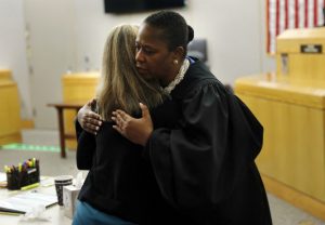State District Judge Tammy Kemp gives former Dallas Police Officer Amber Guyger a hug on Wednesday before Guyger leaves for jail in Dallas. Guyger, who said she mistook neighbor Botham Jean's apartment for her own and fatally shot him in his living room, was sentenced to a decade in prison. (Tom Fox/The Dallas Morning News via AP, Pool)
