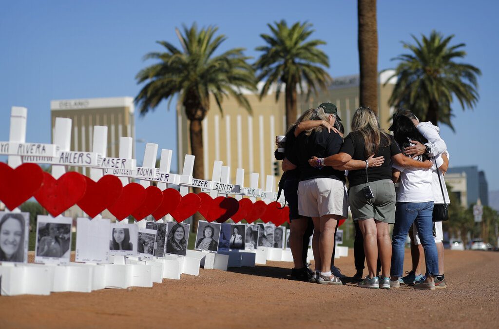 People pray at a makeshift memorial for shooting victims, Tuesday, Oct. 1, 2019, in Las Vegas, on the anniversary of the mass shooting two years earlier. (AP Photo/John Locher)
