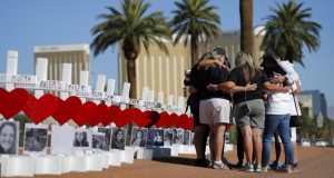 People pray at a makeshift memorial for shooting victims, Tuesday, Oct. 1, 2019, in Las Vegas, on the anniversary of the mass shooting two years earlier. (AP Photo/John Locher)