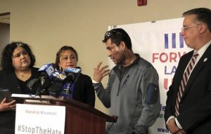 Mahud Villalaz, 42, of Milwaukee gestures at the second-degree burns on his face at a news conference on Saturday one day after a man threw acid at him outside a restaurant on Milwaukee's south side. He is joined, from left, by state Rep. JoCasta Zamarripa, his sister, and the Forward Latino leader Darryl Morin. (Sophie Carson/Milwaukee Journal-Sentinel via AP)