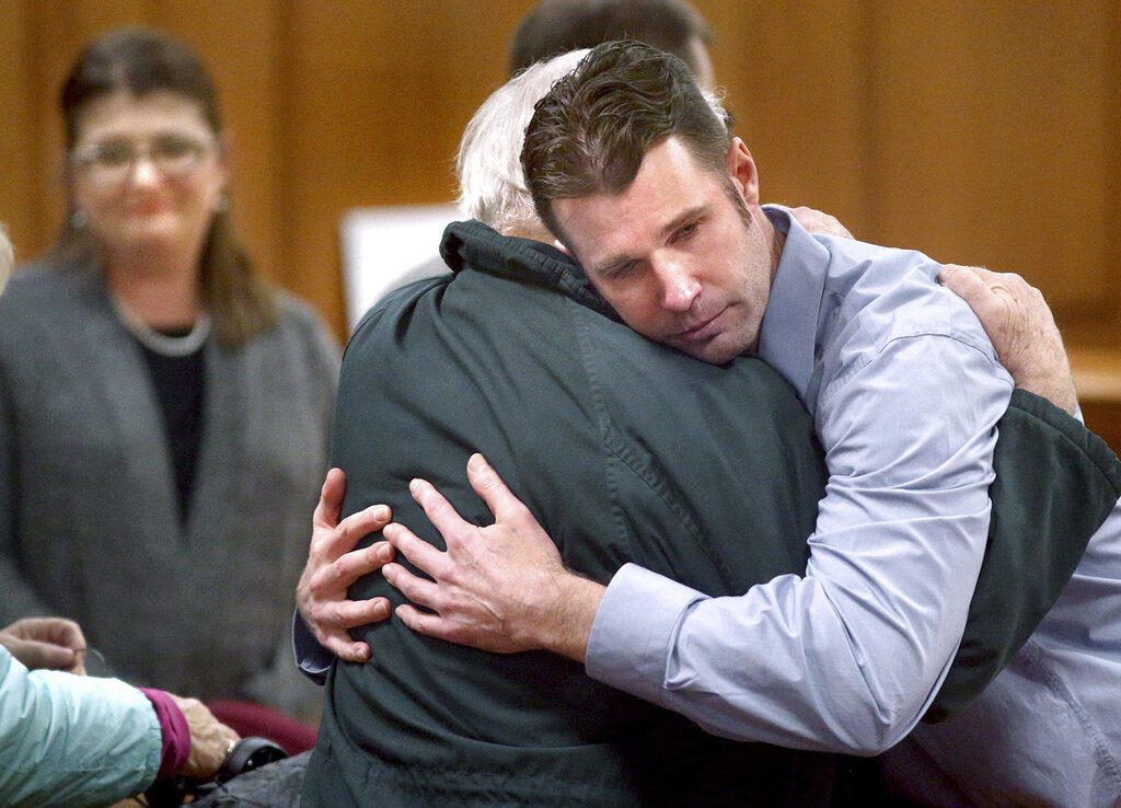 Erik Sackett embraces his father Ron Sackett after a not guilty verdict was announced Thursday, Oct. 31, 2019 at the La Crosse County Courthouse in La Crosse, Wis. A jury has acquitted Erik Sackett, a La Crosse man accused of killing his former girlfriend and disposing of her body in a lake.(Peter Thomson/La Crosse Tribune via AP)