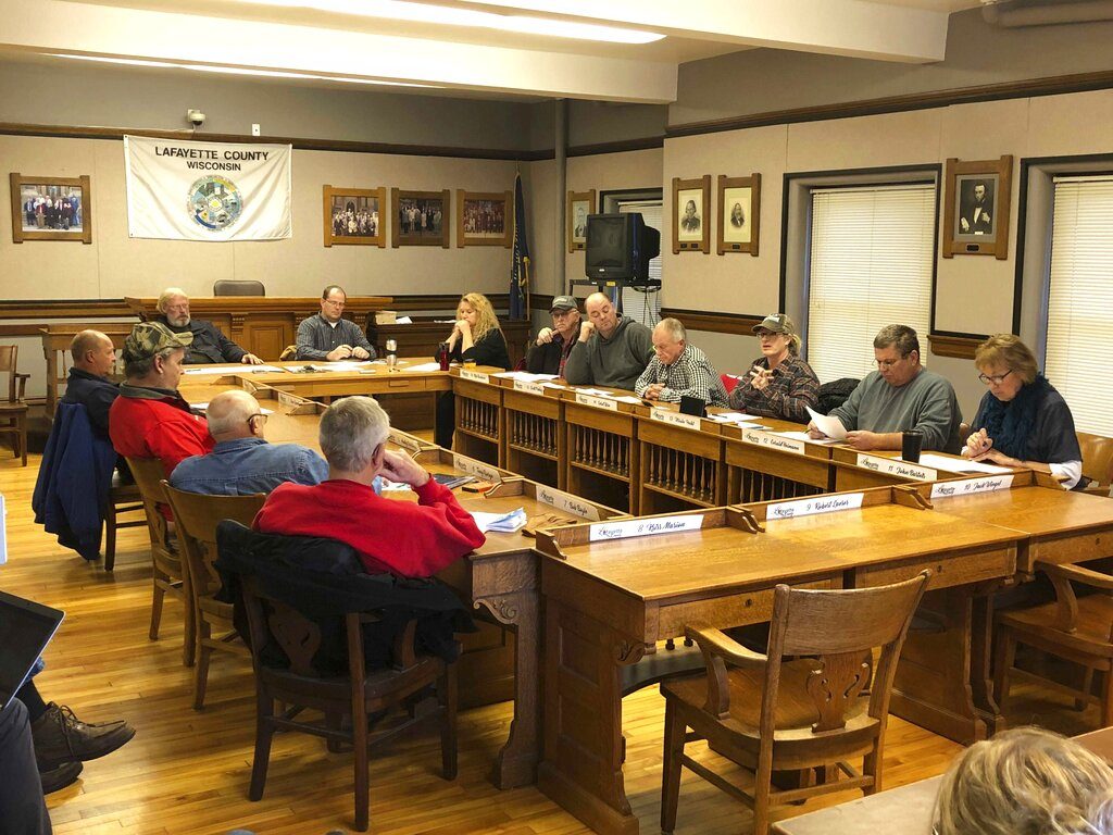 In this Tuesday, Nov. 12, 2019 photo, members of a Lafayette County committee discuss a resolution during a meeting in Darlington, Wis., to discipline county officials who speak about water quality studies without permission. The southwestern Wisconsin county council on Tuesday dropped a proposal to prosecute journalists over their reporting on a water quality study but could still decide to discipline any county officials who talk about the research without government approval. (Patrick Marley/Milwaukee Journal-Sentinel via AP)