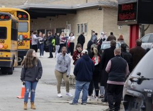 Waukesha South High School students find their parents and friends and hug after fleeing the shots that rung out in their on Monday. A suspect is in custody after a student exchanged gunfire with a school officer on Monday morning, a spokeswoman for the school district confirmed. (Rick Wood/Milwaukee Journal-Sentinel via AP)