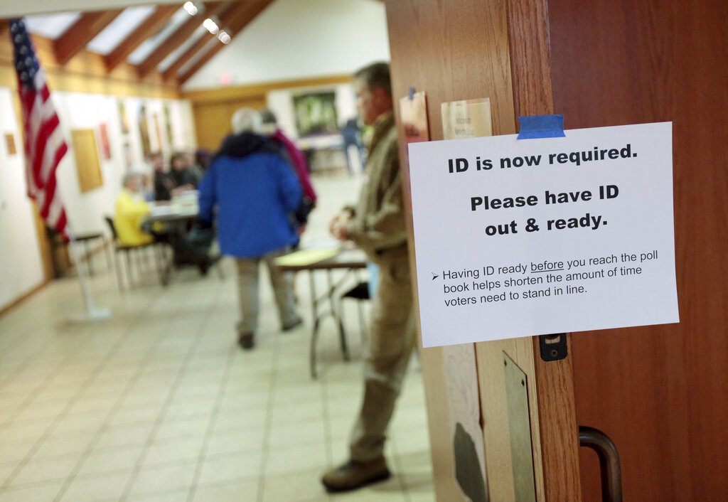 FILE - In this Feb. 16, 2016, file photo, a sign informs voters of the need for identification at the Olbrich Gardens polling location in Madison, Wis. Democrats are hoping this is the year they can finally make political headway in Texas and have set their sights on trying to win a majority in one house of the state legislature. Among the big hurdles they’ll have to overcome are a series of voting restrictions Texas Republicans have implemented in recent years, including the nation’s toughest voter ID law, purging of voter rolls and reductions in polling places. (Michael P. King/Wisconsin State Journal via AP, File)