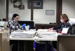 Katherine Katsekes, and Diane Scott, both paid volunteers, help sort absentee ballots by ward on Tuesday at Brookfield City Hall. (Rick Wood/Milwaukee Journal-Sentinel via AP)