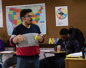 Cesar Martinez, a civics class teacher at Madison East High School, interacts with his students during a Tipping the Scales lecture.