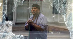 Silvestre Mendez walks by broken glass in the front window of Rising Son's Deli after being damaged in the weekend protests on Monday. Madison police reported that multiple stores were broken into in the State Street area, a business corridor that connects the state Capitol to the University of Wisconsin campus, over the death of George Floyd. Floyd, who was black and handcuffed, died on May 25 after a white Minneapolis police officer used his knee to pin Floyd to the ground for several minutes while Floyd pleaded for air and eventually stopped moving. (Steve Apps/Wisconsin State Journal via AP)