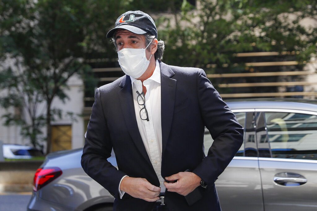 FILE- In this May 21, 2020 file photo, Michael Cohen arrives at his Manhattan apartment in New York after being furloughed from prison because of concerns over the coronavirus. Cohen was furloughed from prison along with other prisoners as authorities tried to slow the spread of the coronavirus in federal prisons. He was returned to prison on July 9, 2020 because he refused to sign an agreement over terms of his home confinement, not because he planned to publish a book critical of Trump, prosecutors said Wednesday, July 22, 2020. (AP Photo/John Minchillo, File)
