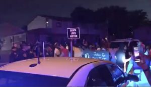 In this image made from video, protesters gather near the site of a police shooting on Sunday in Kenosha,. Officers deployed tear gas early Monday in an effort to disperse hundreds of people who took to the streets following a police shooting in Kenosha that also drew a harsh rebuke from the governor after a video posted on social media appeared to show officers shoot at a Black man’s back seven times as he leaned into a vehicle. (WDJT-TV via AP)