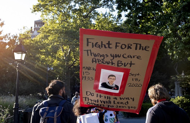 A sign featuring a likeness of Justice Ruth Bader Ginsburg is carried in Washington Square Park on Sept. 19 in New York, a day after the death of the Supreme Court justice. The political battle is being quickly joined over replacing Ginsburg on the Supreme Court. (AP Photo/Craig Ruttle, File)