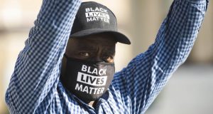 Alvin Nelson holds a sign that reads "Black Lives Matter" outside the Lake County Courthouse in Waukegan, Ill., during Kyle Rittenhouse's second extradition hearing Friday, Sept. 25, 2020. Rittenhouse, accused of killing two protesters days after Jacob Blake was shot by police in Kenosha, Wis., on Friday fought his return to Wisconsin to face homicide charges that could put him in prison for life. (Pat Nabong/Chicago Sun-Times via AP)