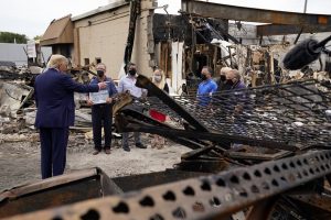President Donald Trump talks to business owners on Tuesday as he tours an area damaged during demonstrations after a police officer shot Jacob Blake in Kenosha. (AP Photo/Evan Vucci)