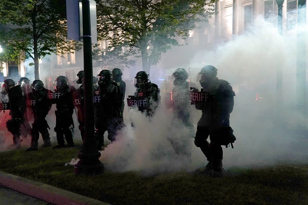 FILE - In this Aug. 25, 2020, file photo police clear a park during clashes with protesters outside the Kenosha County Courthouse in Kenosha, Wis., during demonstrations over the Sunday shooting of Jacob Blake. Unrest over the past week in a critical battleground state could sway the course of the election. (AP Photo/David Goldman, File)