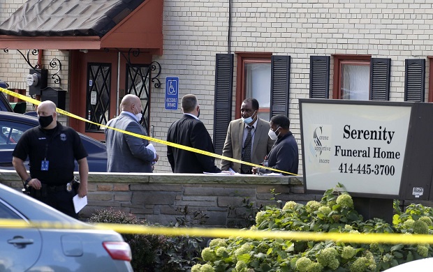 Evidence is gathered after reports of a shooting at Serenity Funeral Home Wednesday in Milwaukee. Several people have been shot and wounded in an apparent drive-by shooting outside the funeral home, but all are expected to survive. Acting Police Chief Michael Brunson said all of the injured are expected to survive and were in stable condition at a local hospital.  (Rick Wood /Milwaukee Journal-Sentinel via AP)