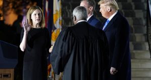 President Donald Trump watches as Supreme Court Justice Clarence Thomas administers the Constitutional Oath to Amy Coney Barrett on the South Lawn of the White House in Washington, Monday, Oct. 26, 2020, after Barrett was confirmed by the Senate earlier in the evening. (AP Photo/Patrick Semansky)