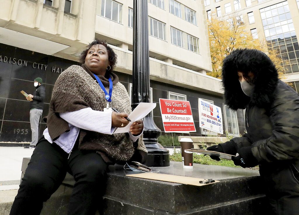 Madison, Wis. residents Theola Carter, left, and Carrie Braxton fill out their ballots on the first day of the state's in-person absentee voting window for the Nov. 3 election outside the city's City-County Building Tuesday, Oct. 20, 2020. (John Hart/Wisconsin State Journal via AP)