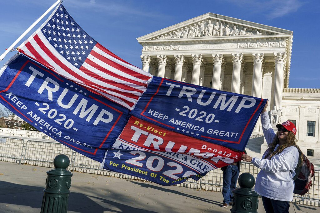 Kathy Kratt of Orlando, Fla., displays her Trump flags as she and other protesters demonstrate their support for President Donald Trump at the Supreme Court in Washington, Friday, Dec. 11, 2020. (AP Photo/J. Scott Applewhite)