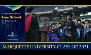 Monique Toshiko Faye Williams, a 2021 Marquette University Law School graduate, walks across the stage at American Family Field during the university's in-person commencement ceremony on Sunday. 