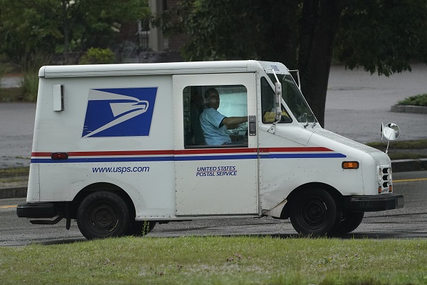 U.S. Postal Service carrier John Graham drives a 28-year-old delivery truck while making's rounds on July 14 in Portland, Maine. Hundreds of the aging trucks were reported to catch fire in recent years. (AP Photo/Robert F. Bukaty)