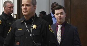 Kyle Rittenhouse is led by a Kenosha County Sheriff officer, as he enters  the courtroom after morning break during his trial at the Kenosha County Courthouse in Kenosha on Thursday. Rittenhouse is accused of killing two people and wounding a third during a protest over police brutality in Kenosha, last year.  (Mark Hertzberg /Pool Photo via AP)