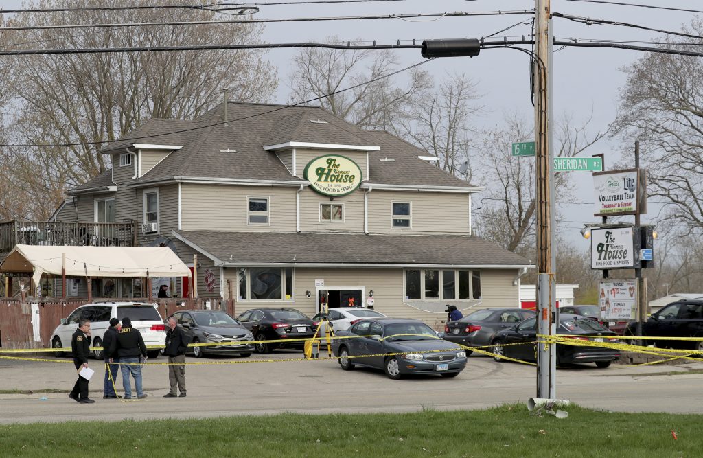 FILE - Officials investigate the scene of a deadly shooting at Somers House Tavern in Kenosha, Wis., April 18, 2021. A jury has been selected in Kenosha County Circuit Court to hear the case against a man charged with killing three people and wounding three others in a shooting at a crowded bar. Twenty-five-year-old Rakayo Vinson is facing three counts of first-degree intentional homicide and three counts of attempted first-degree intentional homicide in the shooting at Somers House Tavern. Opening statements are expected Tuesday, Jan. 11, 2022. (Mike De Sisti/Milwaukee Journal-Sentinel via AP)